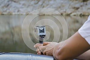 Hand holding small action camera with waterproof case