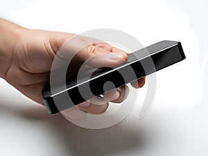 A hand holding a small black rectangular object