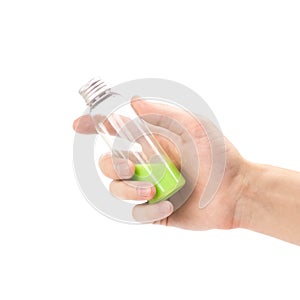 Hand holding a small bottle of green liquid. Close up. Isolated on a white background