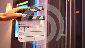 Hand is holding Small Clapperboard or movie slate  in front of cinemas . It use in video production, film industry.Black color