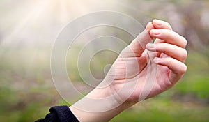 Hand holding a small mustard seed