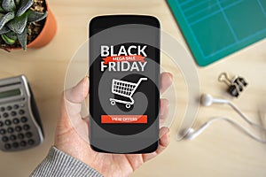 Hand holding smart phone with Black Friday concept on screen