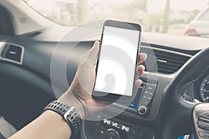 Hand holding smart phone in car