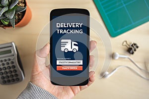 Hand holding smart phone with delivery tracking concept on scree