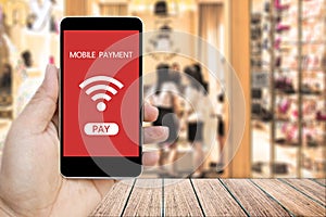 Hand holding smart phone with mobile payment.