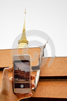 Hand holding smart phone (Mobile Phone) with pagoda and temple r