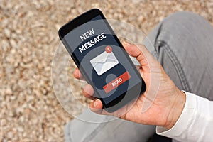 Hand holding smart phone with new message concept on screen