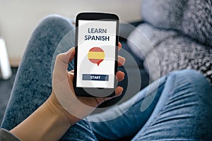 Hand holding smart phone with online learn spanish concept on sc