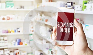 Hand holding smart phone in pharmacy drugstore photo