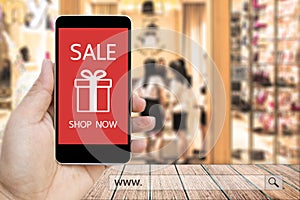 Hand holding smart phone with sale paynow on screen and www. search bar.