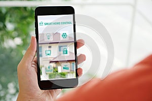 Hand holding smart phone with smart home control icon on screen device, smart home control concept