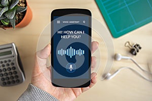 Hand holding smart phone with voice assistant concept on screen