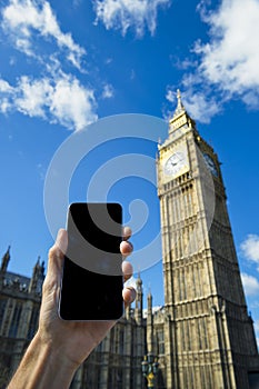 Hand Holding Smartphone at Big Ben Westminster Palace London