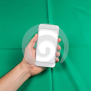 Device has a white casing and is held against a solid green fabric