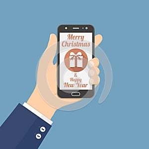 Hand holding smartphone with Christmas gift icon on screen