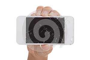 Hand holding smartphone with cracked screen