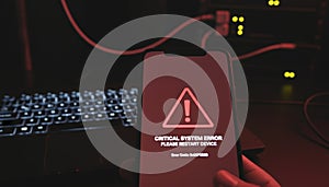 Hand holding smartphone displaying critical system error message