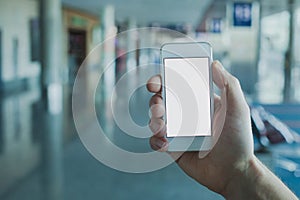 hand holding smartphone with empty blank screen in airport, mobile app