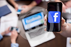 Hand holding smartphone with facebook logo icon on screen