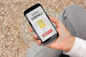 Hand holding smartphone with we are hiring apply now concept on