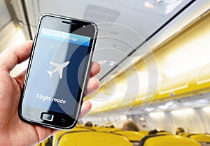 Hand holding smartphone inside the plane