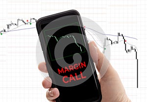 Hand holding a smartphone with the message margin call photo