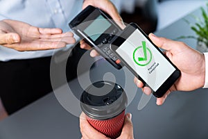 Hand holding smartphone with NFC QR code device. fervent