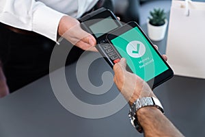 Hand holding smartphone with NFC QR code device. fervent