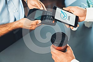 Hand holding smartphone with NFC QR code device. fervent