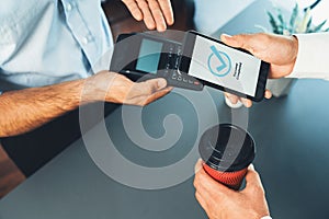 Hand holding smartphone with NFC QR code device. fervent