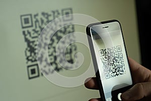 Hand holding smartphone, scanning qr code with smartphone