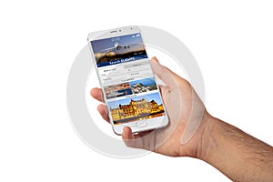 Hand holding a smartphone, search flights on the screen, isolated on white backgound.