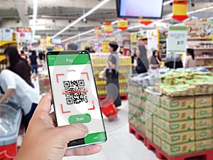 Hand holding smartphone to scan QR code payment , online shopping , cashless concept