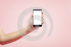 Hand holding smartphone with white blank screen on pink background