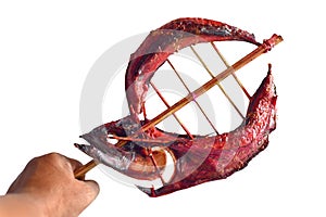 Hand holding the smoked tuna fish on a bamboo