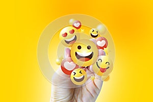 Hand holding Social media icons, online social communication applications concept, emoji, hearts, chat isolated on yellow