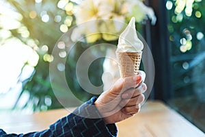 A hand holding soft serve ice cream cone