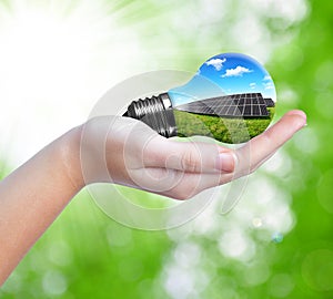 Hand holding solar panels in light bulb