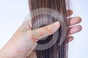 The hand is holding the split ends, dry and uneven color of woman`s hair. Haircare problems for women