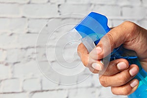 Hand holding spray bottle for cleaning surface for coronavirus