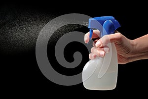 Hand holding and spraying spray bottle
