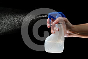 Hand holding and spraying spray bottle