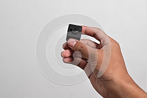 Hand holding a spy camera, Black security camera