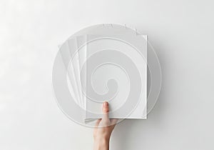 Hand holding stack of blank white paper sheets