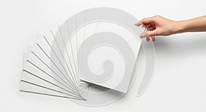 Hand holding stack of blank white paper sheets