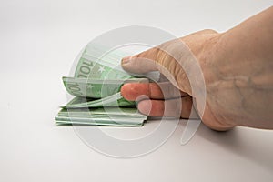 Hand Holding Stack of 100 Euro Banknotes
