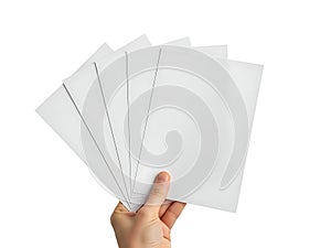 Hand holding stack of white paper sheets