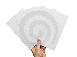 Hand holding stack of white printer papers