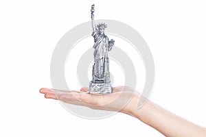 Hand holding a Statue of Liberty souvenir toy