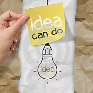 Hand holding sticky note with idea can do word light bulb on cr